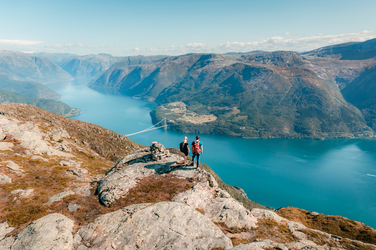 Foto av ett par på fjelltur, ser på utsikt mot hardangerfjorden. Hører til lenke til landingsside høst.