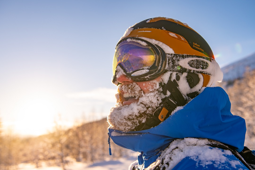 mann med pudder i skjegget etter å ha stått på ski