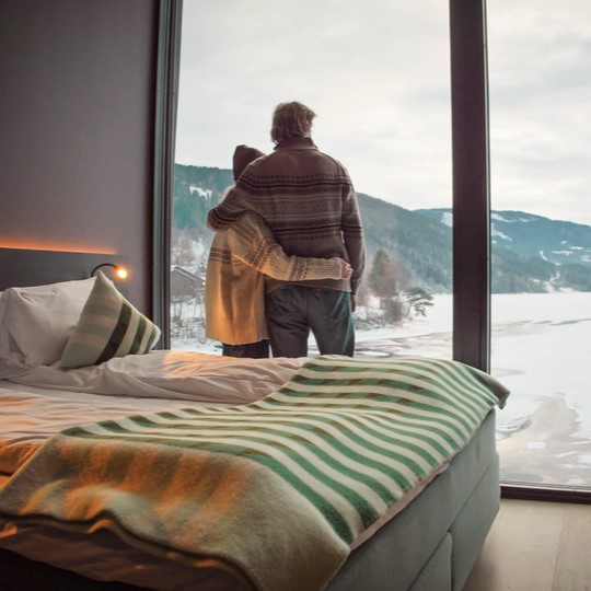 Par ser ut på vinterlandskapet, gjennom de store vinduene på elva hotell