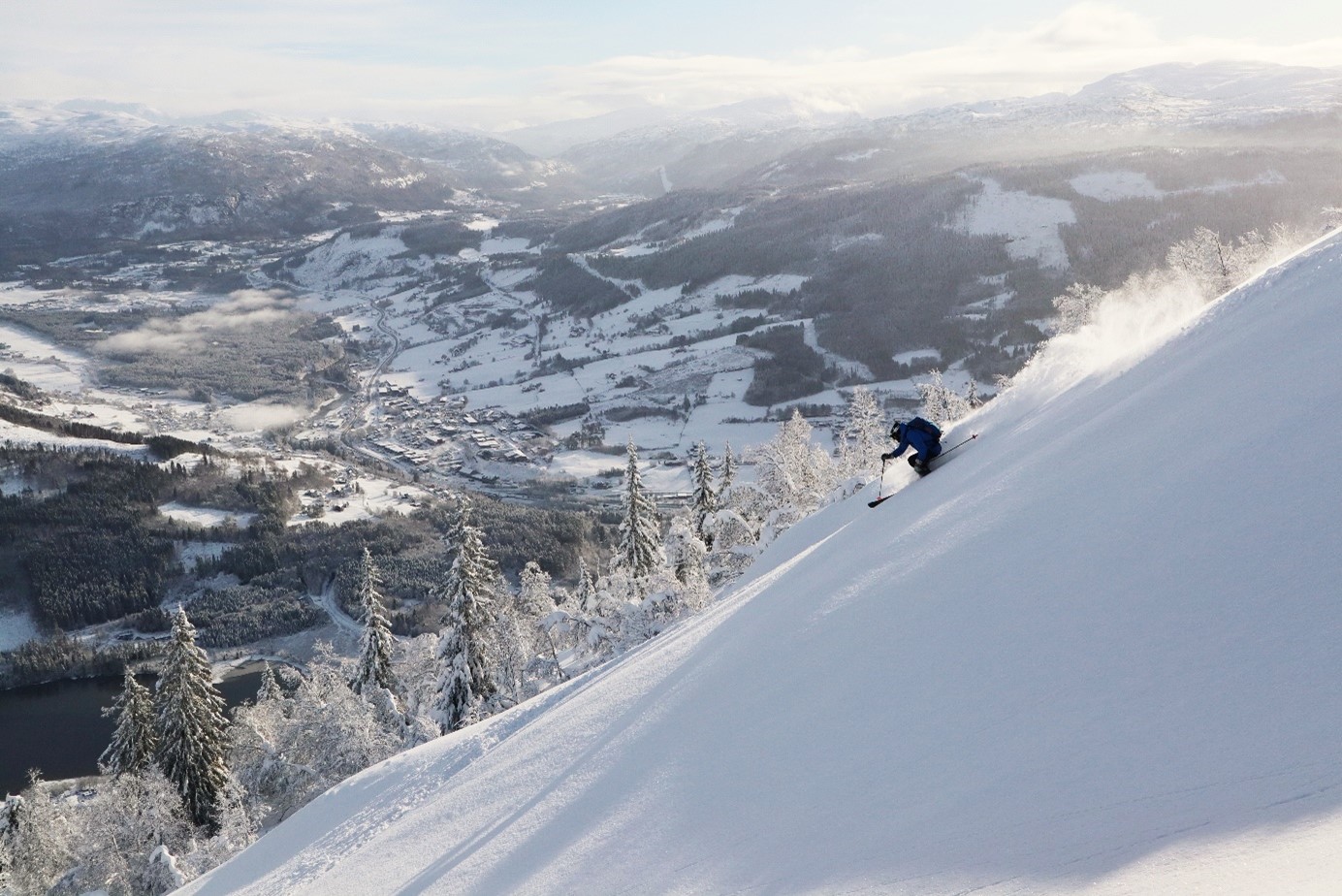 mann på ski i voss resort, bebyggelsen like i bakgrunnen