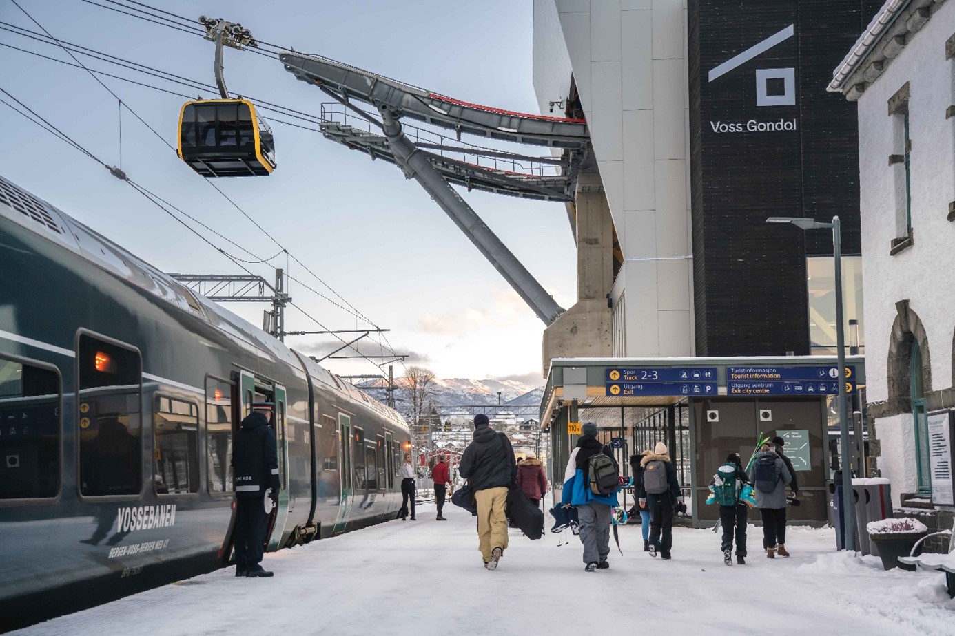 perrongen på voss stasjon, folk med skiutstyr på vei fra toget som har stoppet til voss gondol