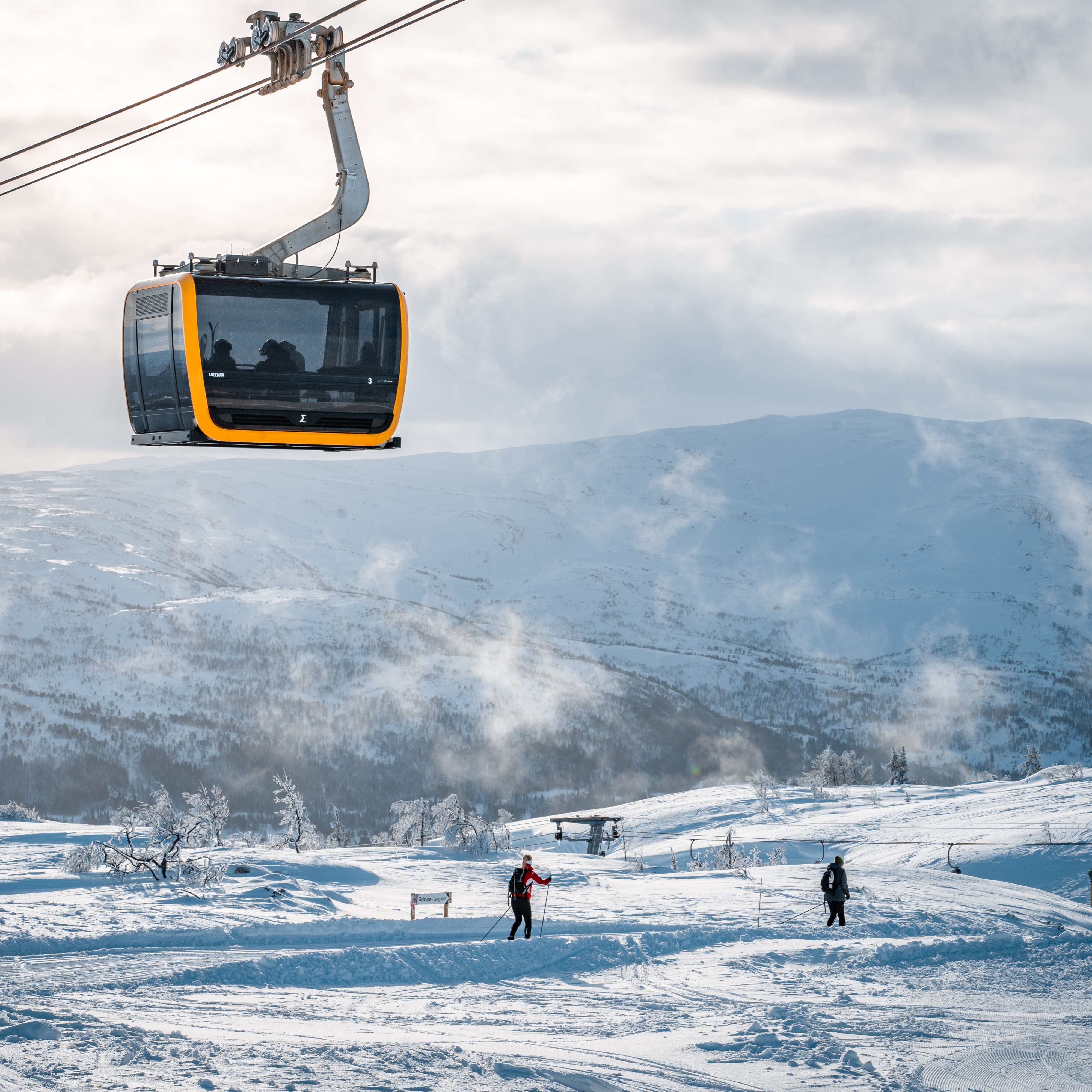 folk på langrenn i voss resort, gondolen går på siden av bildet