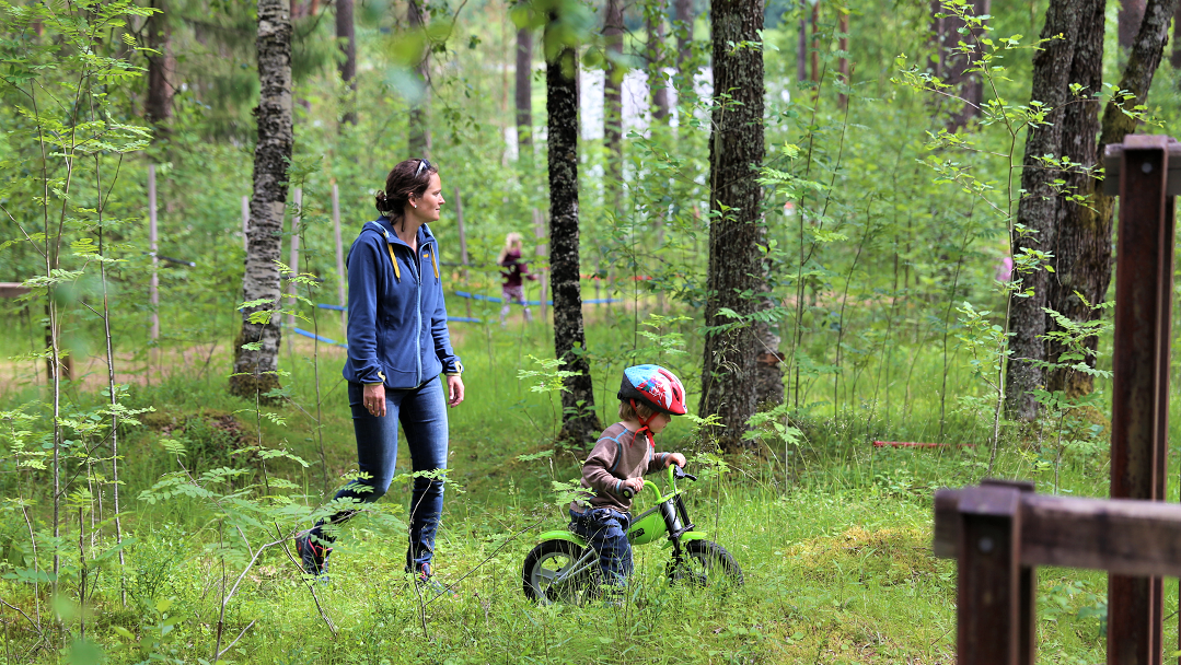 mor følger barn på sykkel i bømoen