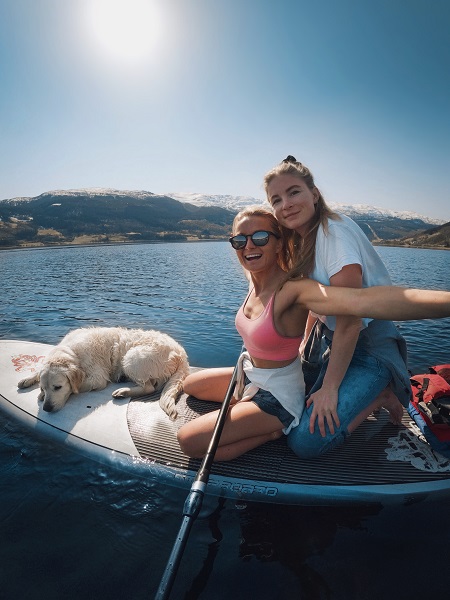 Ein hund og to jenter på SUP-brett på Vangsvatnet