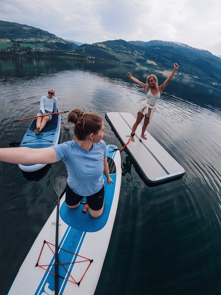 tre jenter på sup-brett på vangsvatnet