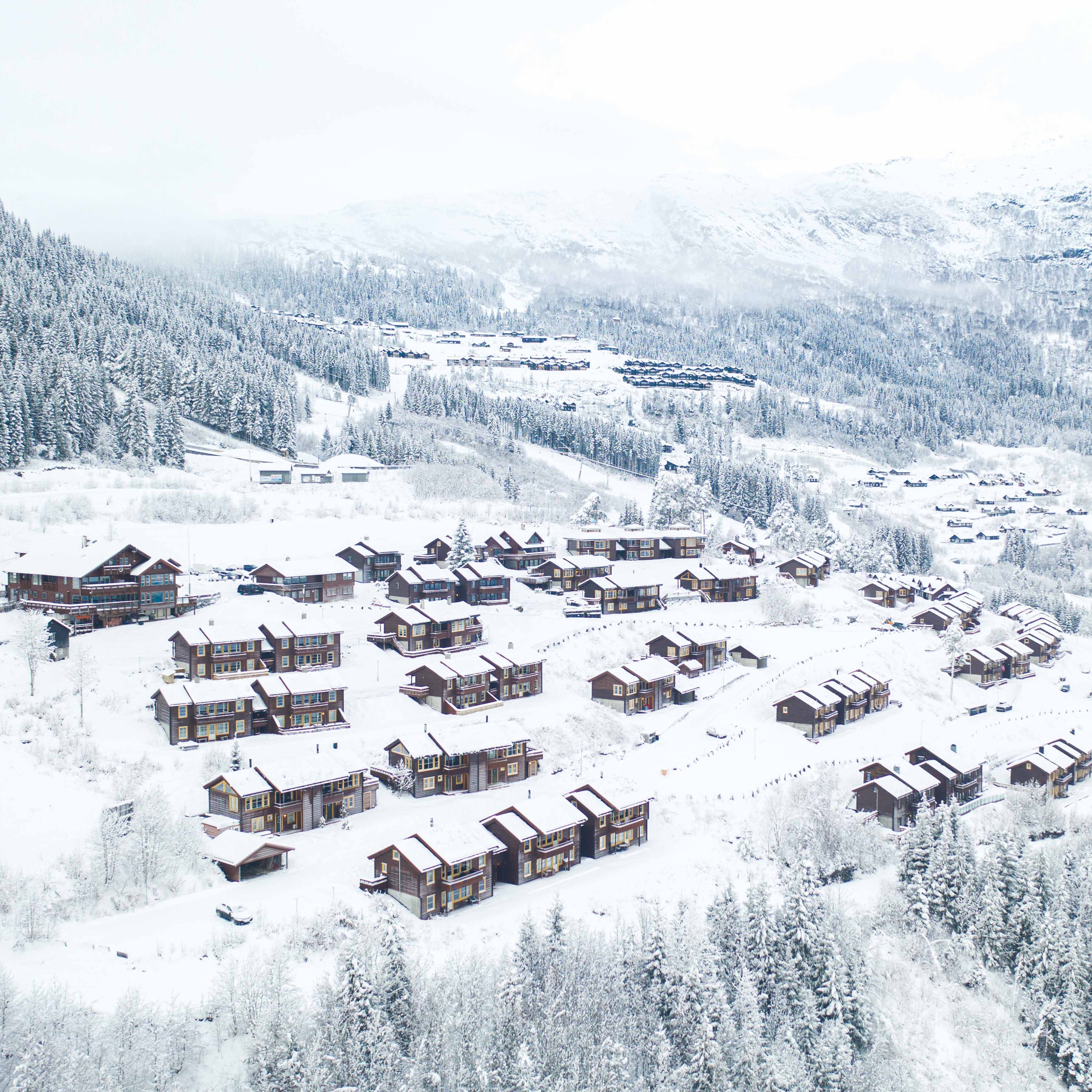 hyttetun i bavallen, voss resort, i forgrunnen. I bakgrunnen ser ein nokre av hyttene i tråstølen. Alle er dekt av snø og og det er godt med snø rundt i anlegget.