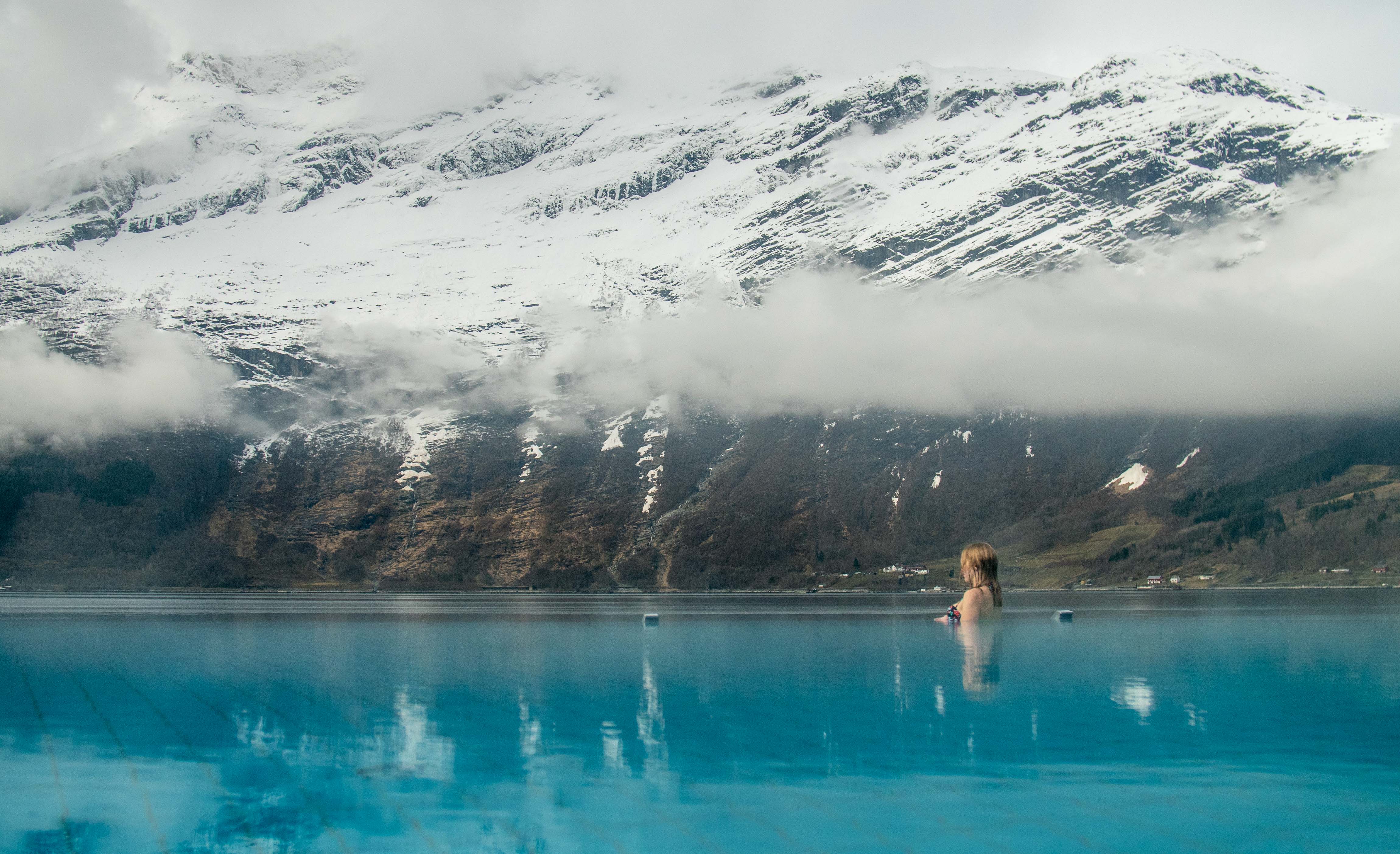 Dame i utebassenget på hotel ullensvang. infinity pool som går ut i fjorden