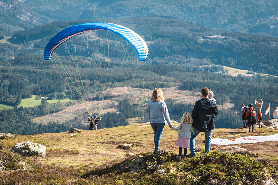 Familie ser på paraglider ved Voss Gondol