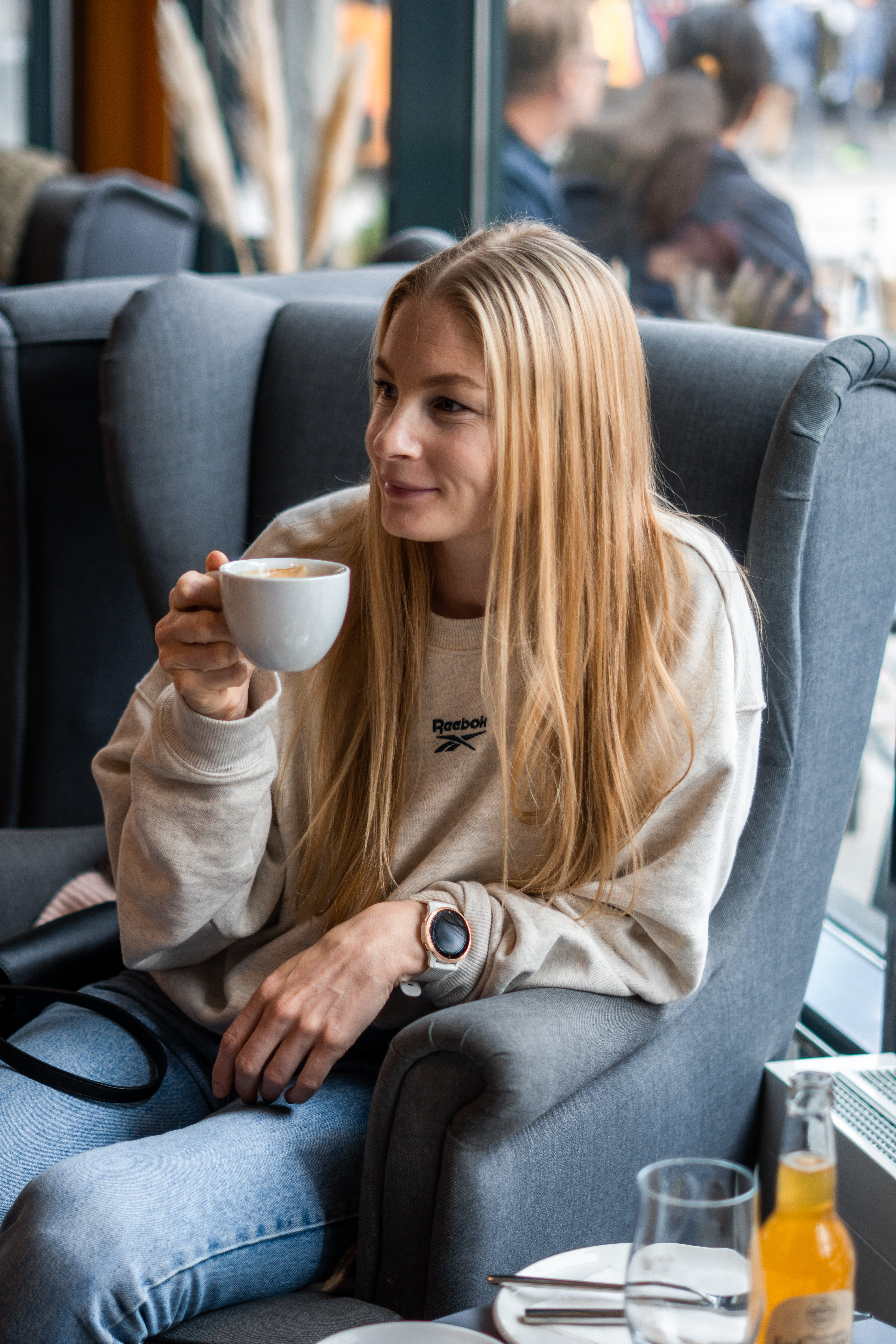 dame drikker cappucino på vangen cafe