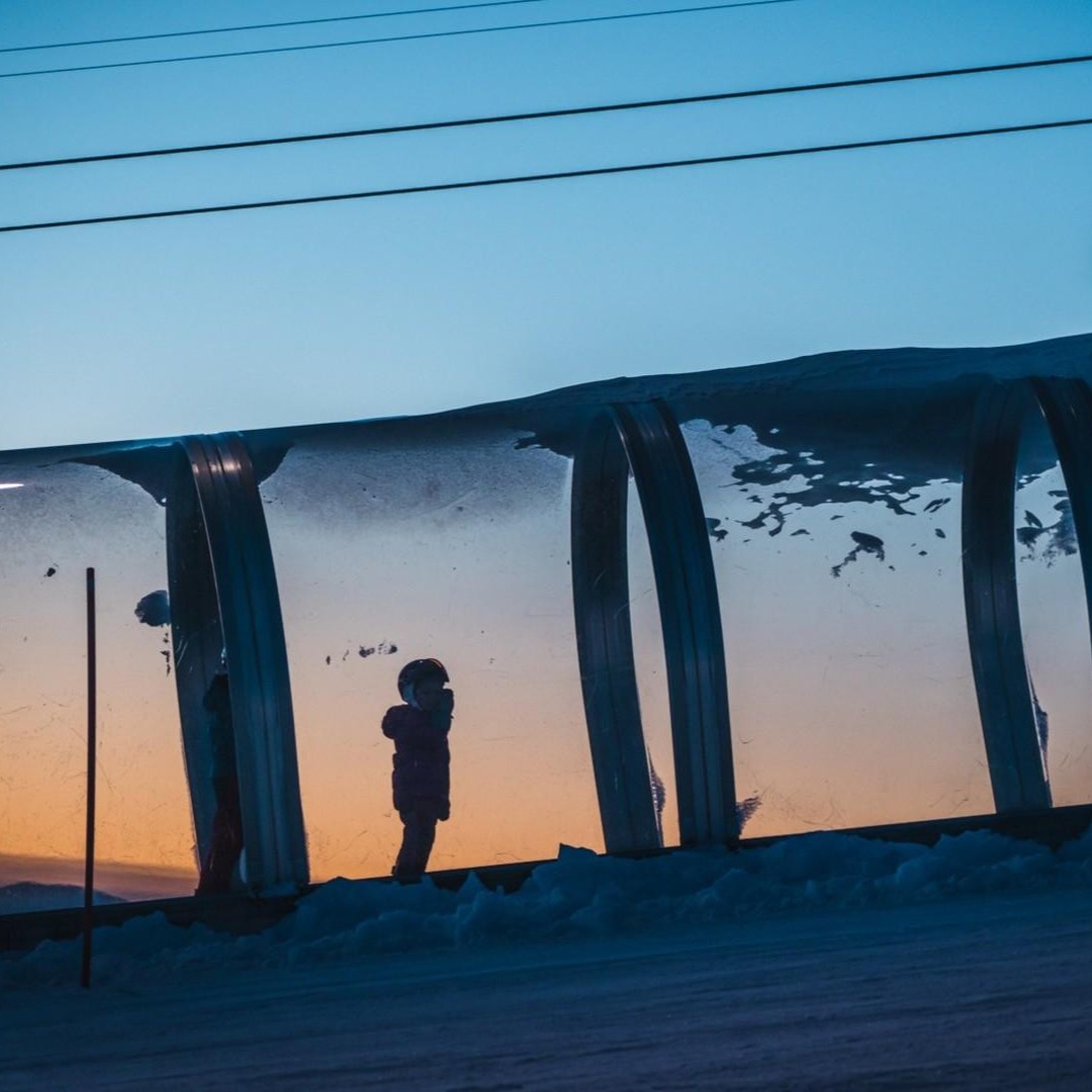 barn i skitrekk på kvelden, i solnedgang