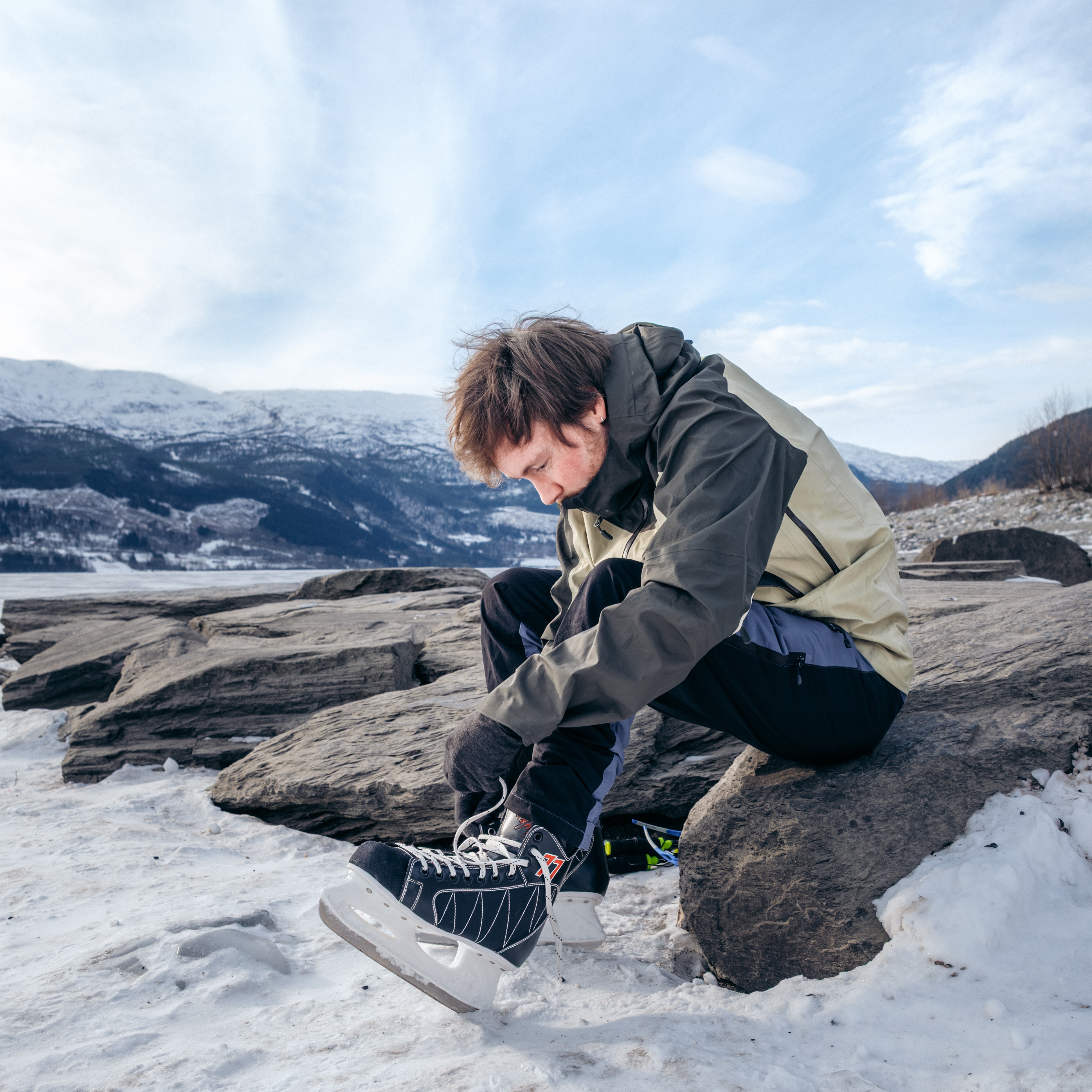 mann knyter skøytene sine ved Vangsvatnet (Voss)