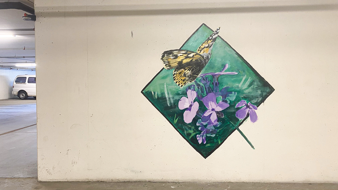 gatekunstverk av ein sommarfugl og nokre blomar i voss parkeringshus