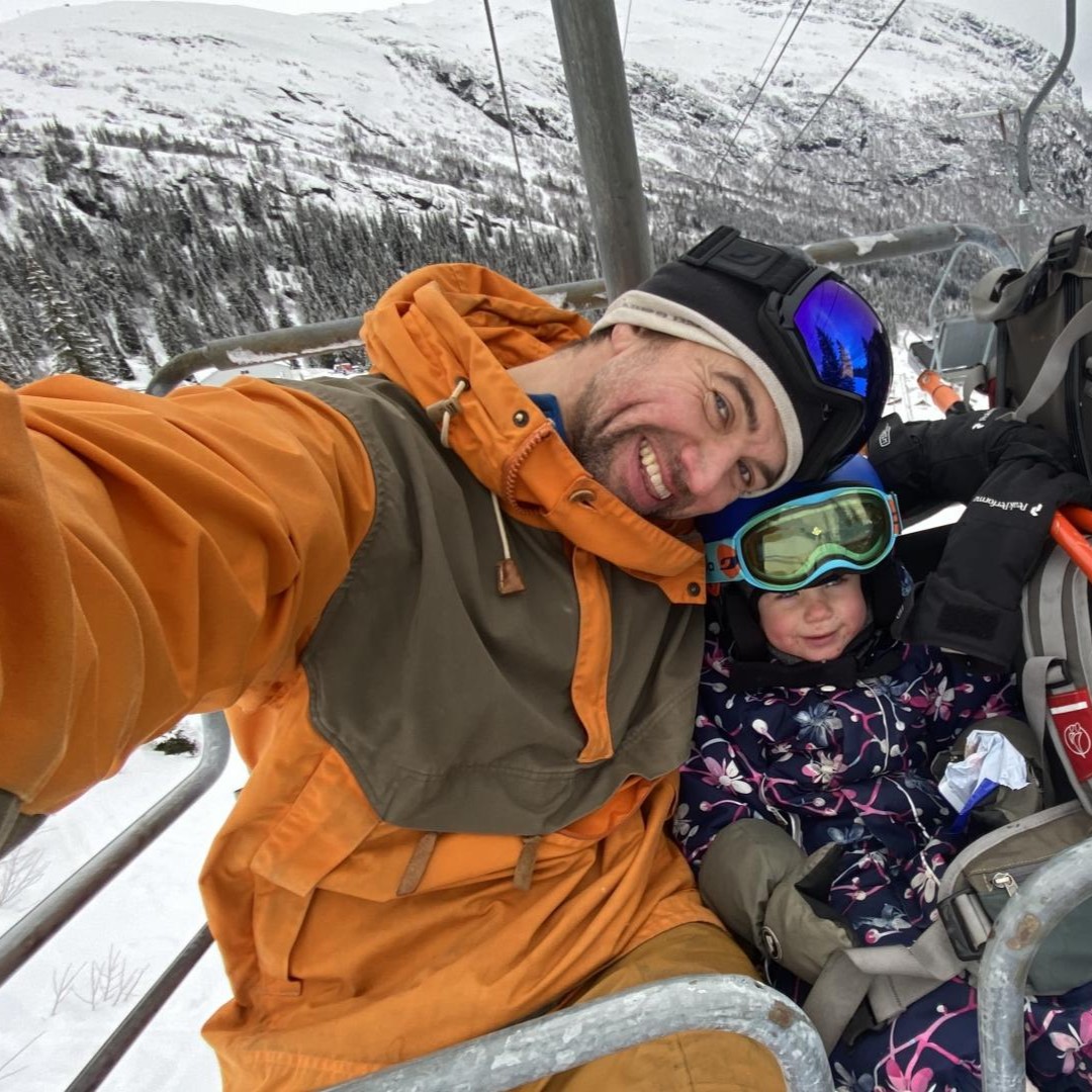 mann og barn tar selfie i skitrekket. Begge ikledd vinterutstyr.